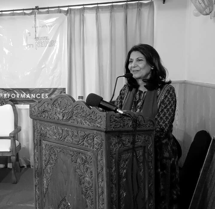 A speaker addressing the festival from the carved walnut podium